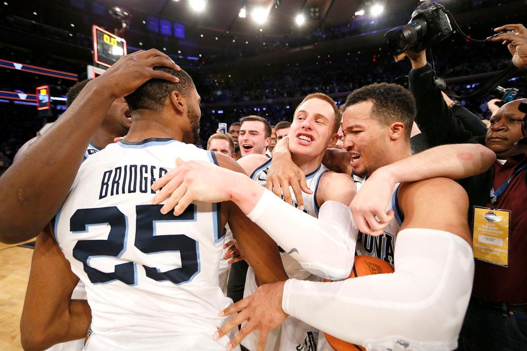 Mikal Bridges #25 of the Villanova Wildcats along with Donte DiVincenzo #10 of the Villanova Wildcats and Jalen Brunson #1 of the Villanova Wildcats celebrate after The Villanova Wildcats defeat the Providence Friars 76-66 in over time during the final game of the Big East Basketball tournament at Madison Square Garden on March 10, 2018. 