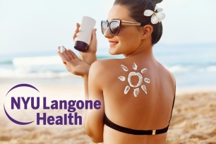 Woman on the beach with a sunscreen sun shape on her shoulder