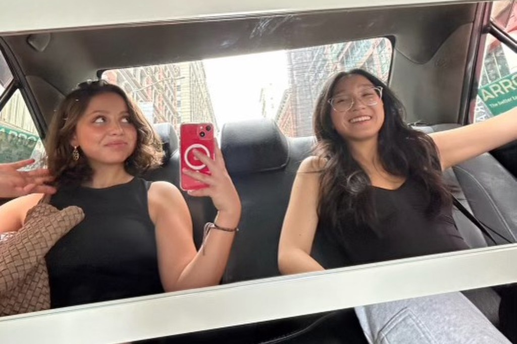 Agapov, left, holding a red cell phone and taking a selfie in the back seat of a car with Fung, right