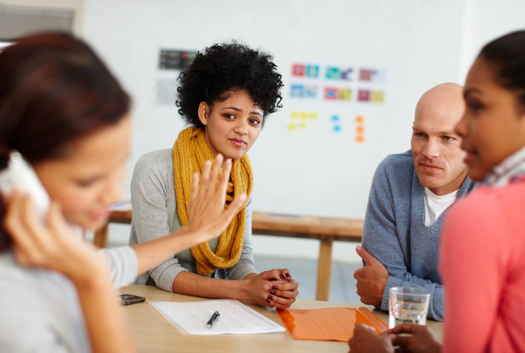 Gen Z employee talking on phone at desk, gesturing for silence, while displeased coworkers look on in an office setting