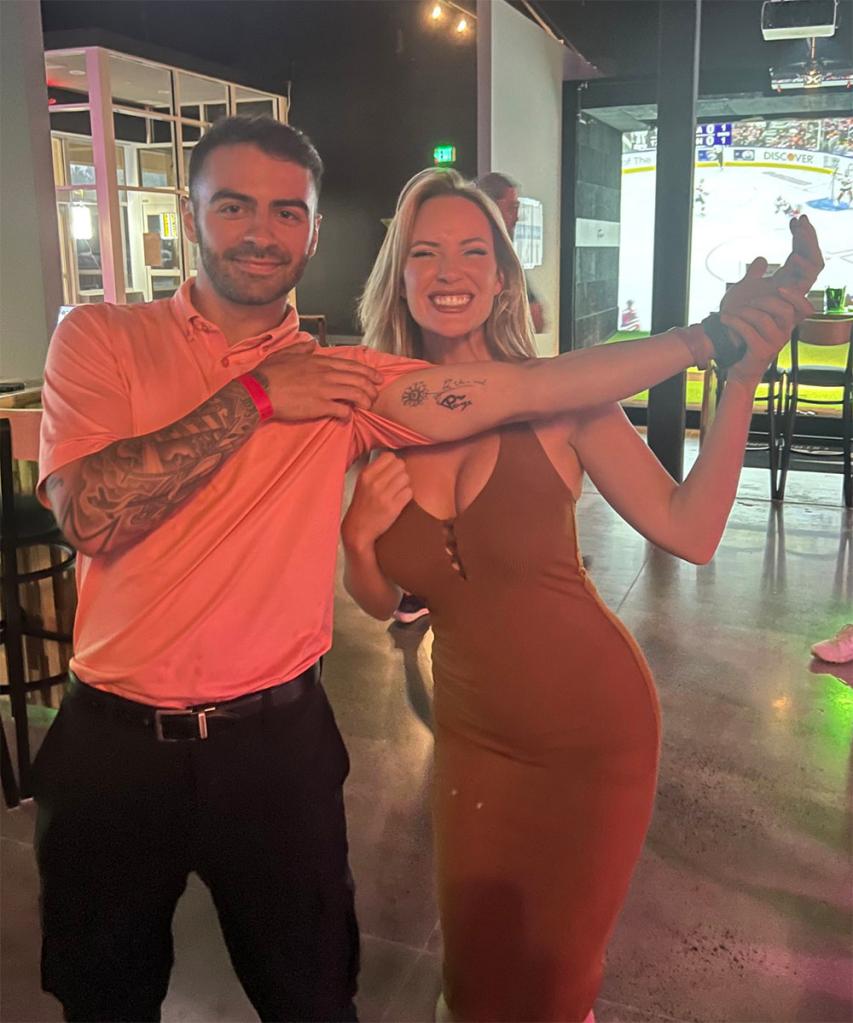 Paige Spiranac poses for a photo with a fan named Tony after he got her name tattooed on his arm   at an event for X-Golf in Los Angeles.