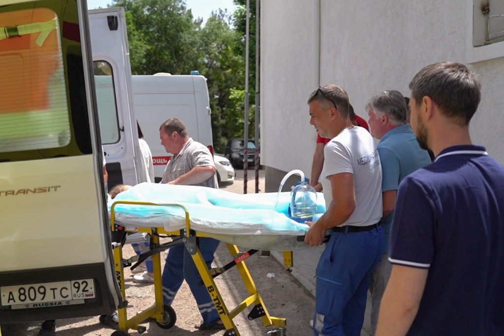 Paramedics outside Sevastopol's children's hospital, transporting injured children to a plane for treatment in Moscow following a Ukrainian missile strike