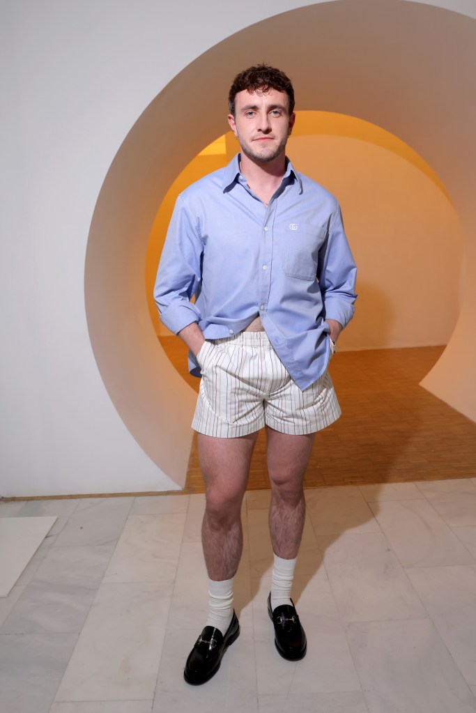 Paul Mescal sitting front row at the Gucci Men's Spring Summer 2025 Fashion Show in Milan, wearing a blue shirt and shorts