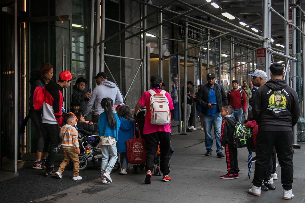 People exit the Row Hotel, currently a migrant shelter, in the Times Square neighborhood of New York City on Friday, May 10, 2024. 