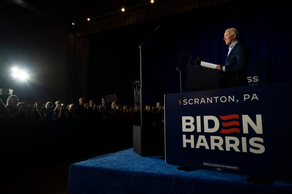 President Joe Biden speaking at a podium during a campaign event in Scranton, Pennsylvania, with a crowd of people listening.
