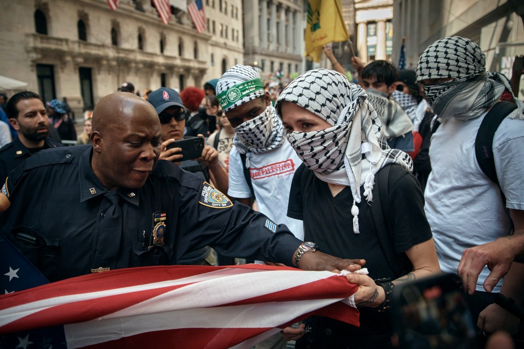Pro-Palestinian protester tries to grab an American flag from Pro-Israel supporters