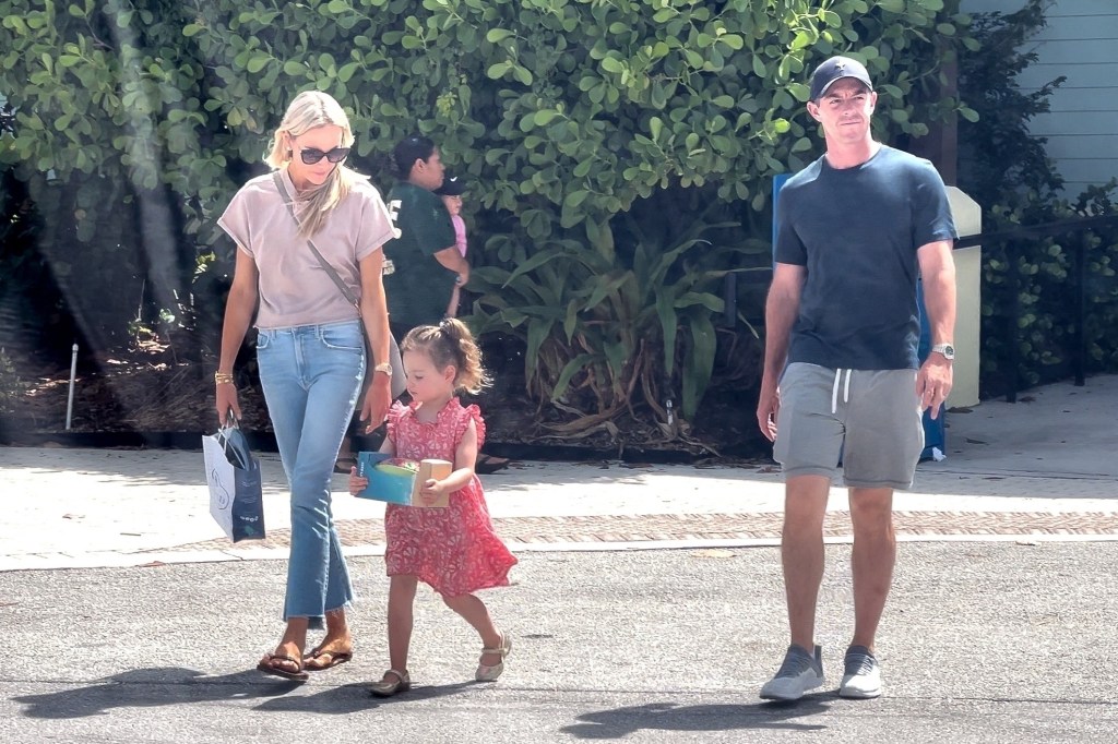 Rory McIlroy walks alongside his wife Erica Stoll and daughter Poppy on Monday.