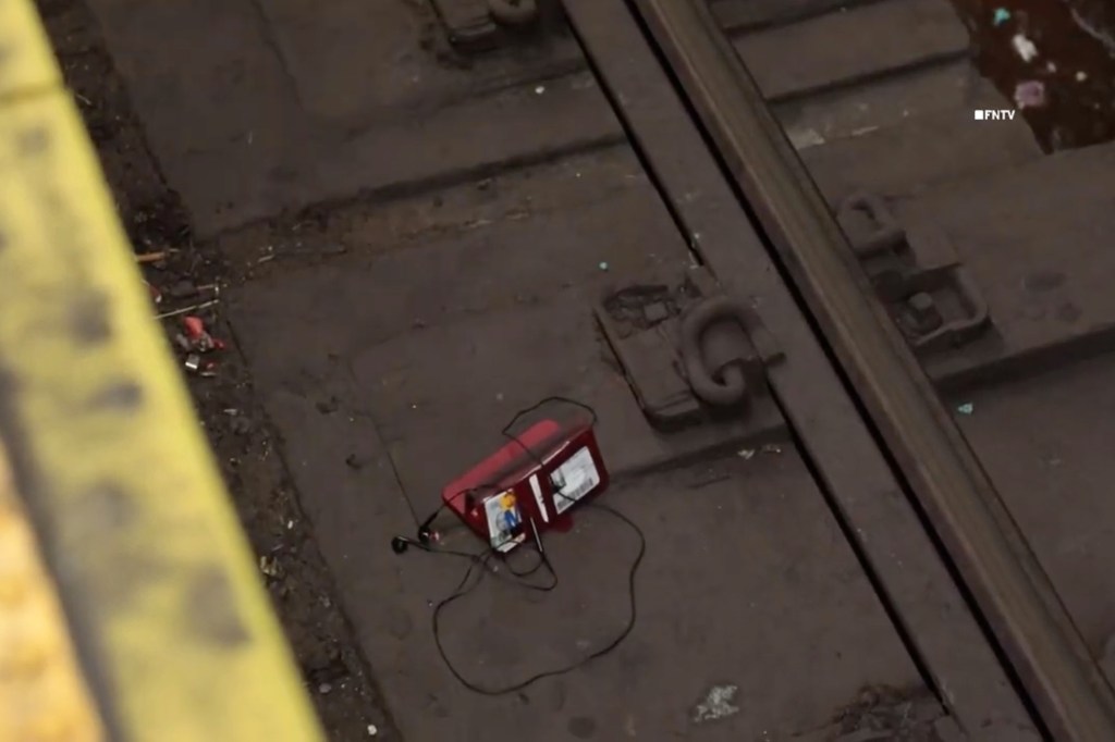 A cellphone and wallet on the tracks.