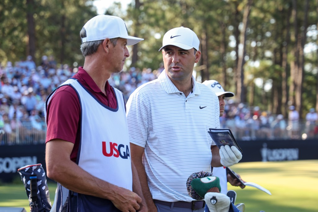 Scottie Scheffler (r) speaks with his caddie Ted Scott.