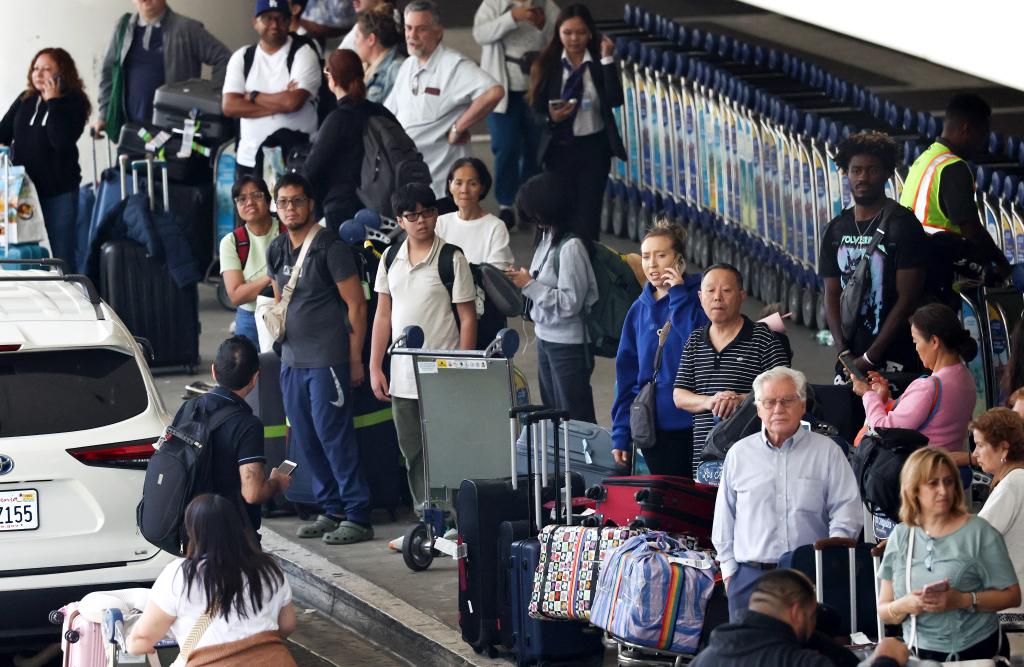 LOS ANGELES, CALIFORNIA - JUNE 25: Travelers gather with their luggage outside the international terminal at Los Angeles International Airport (LAX) ahead of the July 4th holiday travel period on June 25, 2024 in Los Angeles, California. The Transportation Security Administration (TSA) screened 2.99 million passengers on June 23, a single day record. TSA is prepared to screen over 32 million passengers from June 27 through July 8 during the 2024 Independence Day holiday travel period.