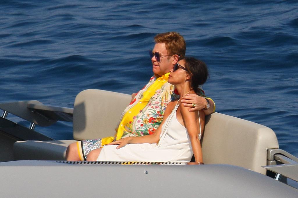 David Beckham shirtless, holding hands with Harper and jumping off a luxury yacht, while Elton John, Victoria, and others watch on