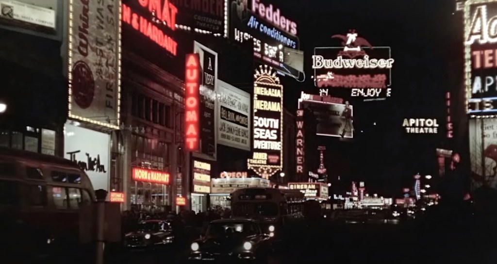 An automat's neon sign stands out among other brightly lit facades in New York City.