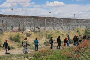 A group of migrants walking near the border wall in Ciudad Juarez, Mexico, on 26 May 2024