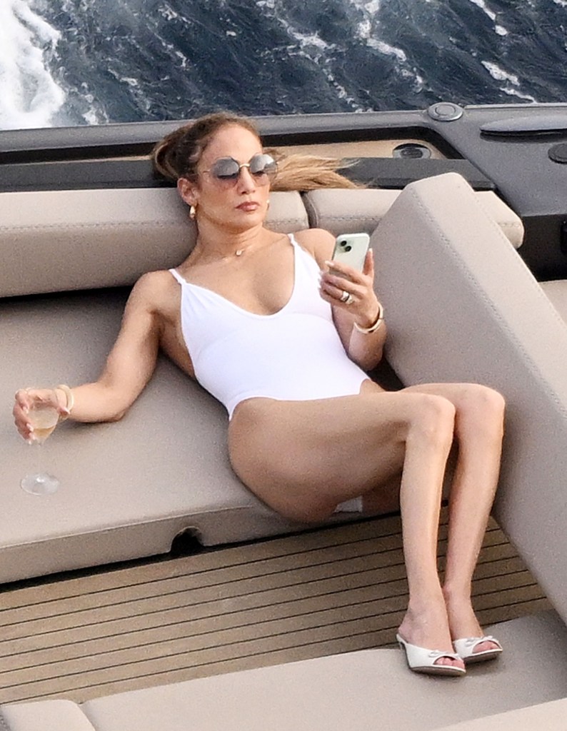 J-Lo on a boat looking at her phone. 