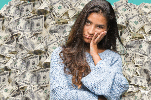 Woman looking stressed surrounded by cash