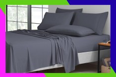 A bed with grey sheets.