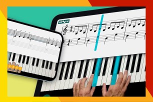 Hands playing piano on a tablet.