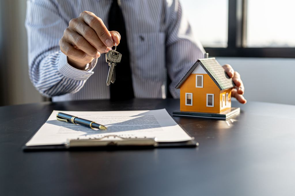 Home rental company employee handing over house keys to a customer while explaining rental contract