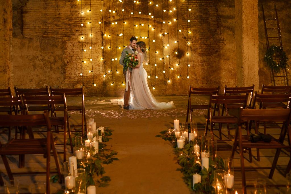 Couple tying the knot in candlelit ceremony. 