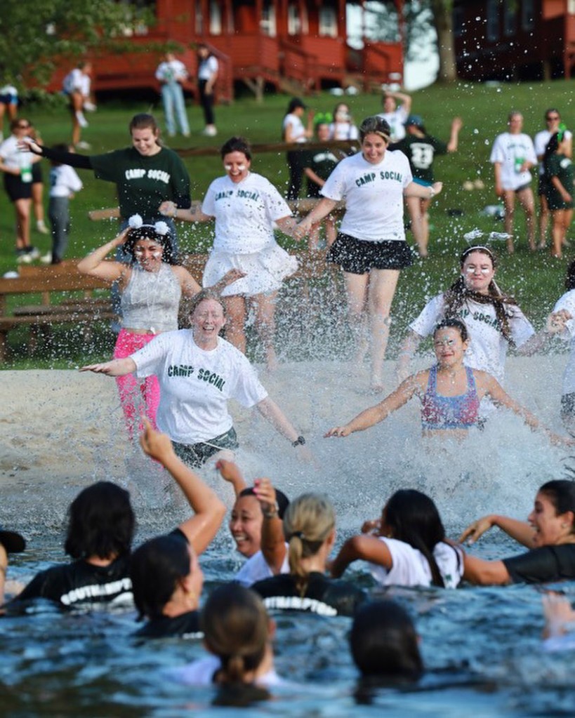 Women running into the lake at Camp Social 