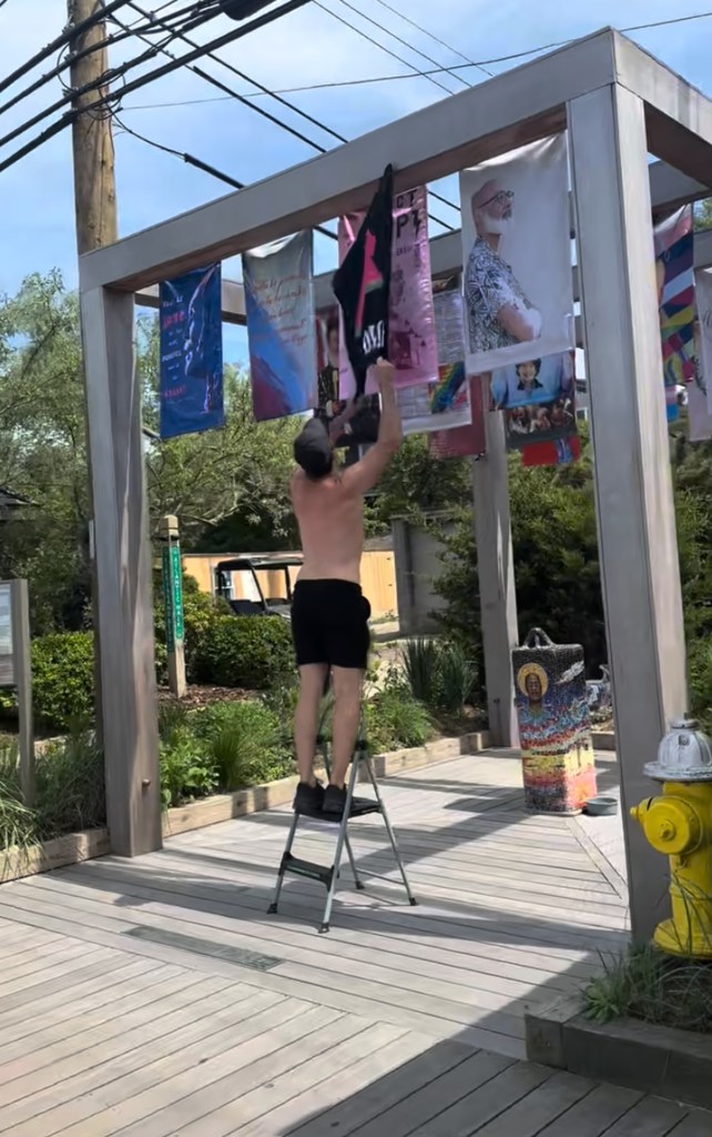 A man standing next to a flag honoring pro-Israel Rep. Ritchie Torres in Trailblazers Park, recently ripped down