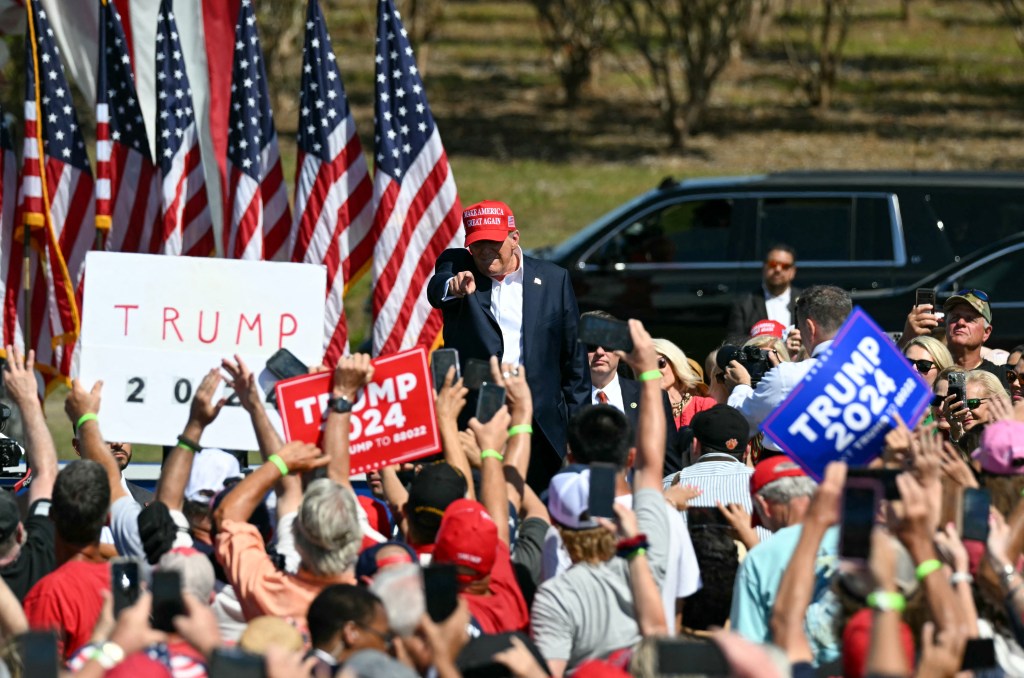 Trump enters the rally, pointing to supporters.