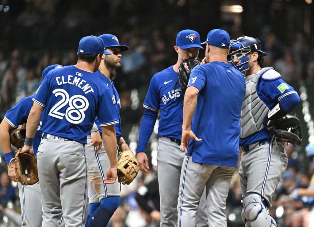Toronto Blue Jays pitching coach Pete Walker in conversation with pitcher Trevor Richards and catcher Danny Jansen during a game against Milwaukee Brewers