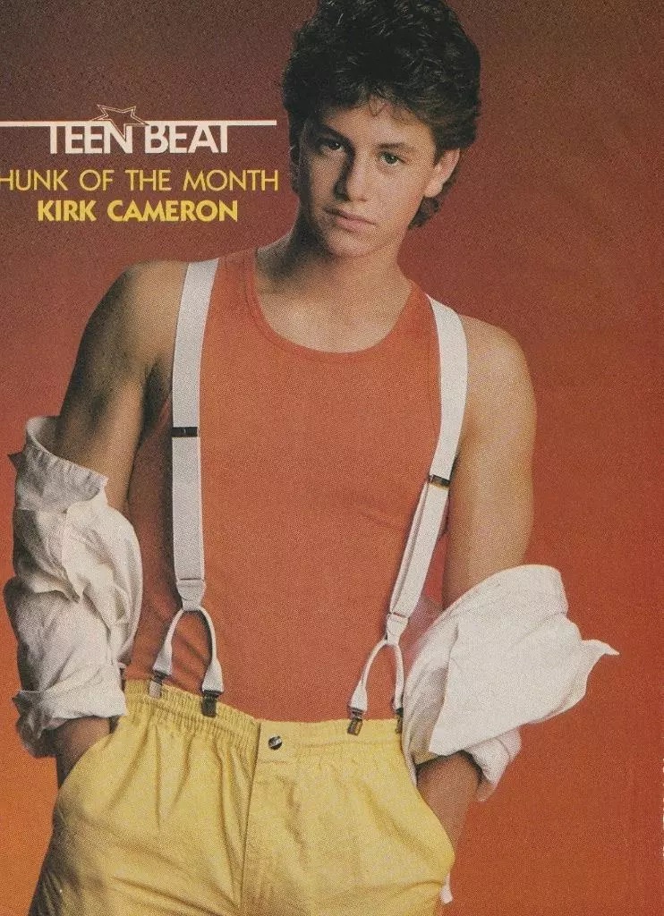 teen beat poster of "hunk of the month" Kirk cameron in a red tank top with  white suspenders
