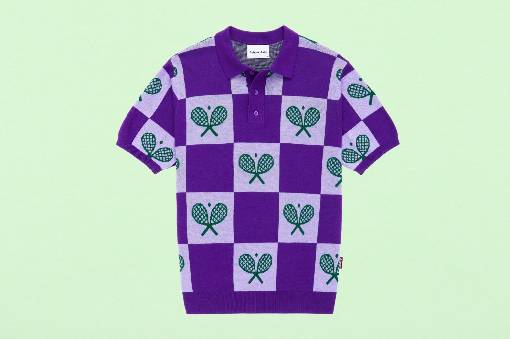 A purple and green tennis polo shirt displayed on a fresh green paper texture background