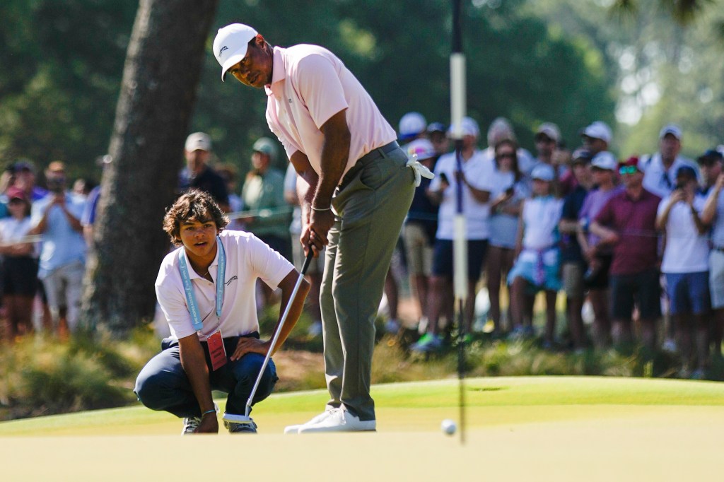 Tiger Woods putts as his son Charlie watches on the seventh hole during a U.S. Open practice round on Tuesday.