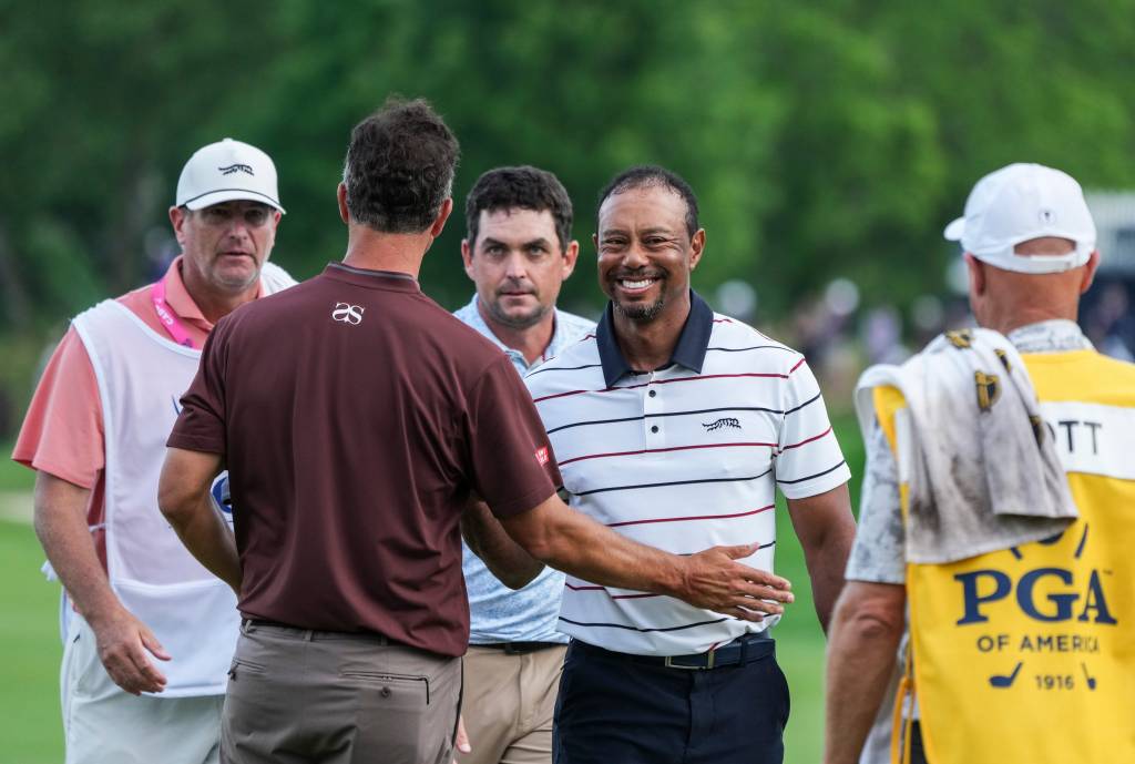 Tiger Woods smiles after finishing his round of golf with golfers Adam Scott and Keegan Bradley at the 18th green late Friday at the 2024 PGA Championship second round at Valhalla Golf Course.