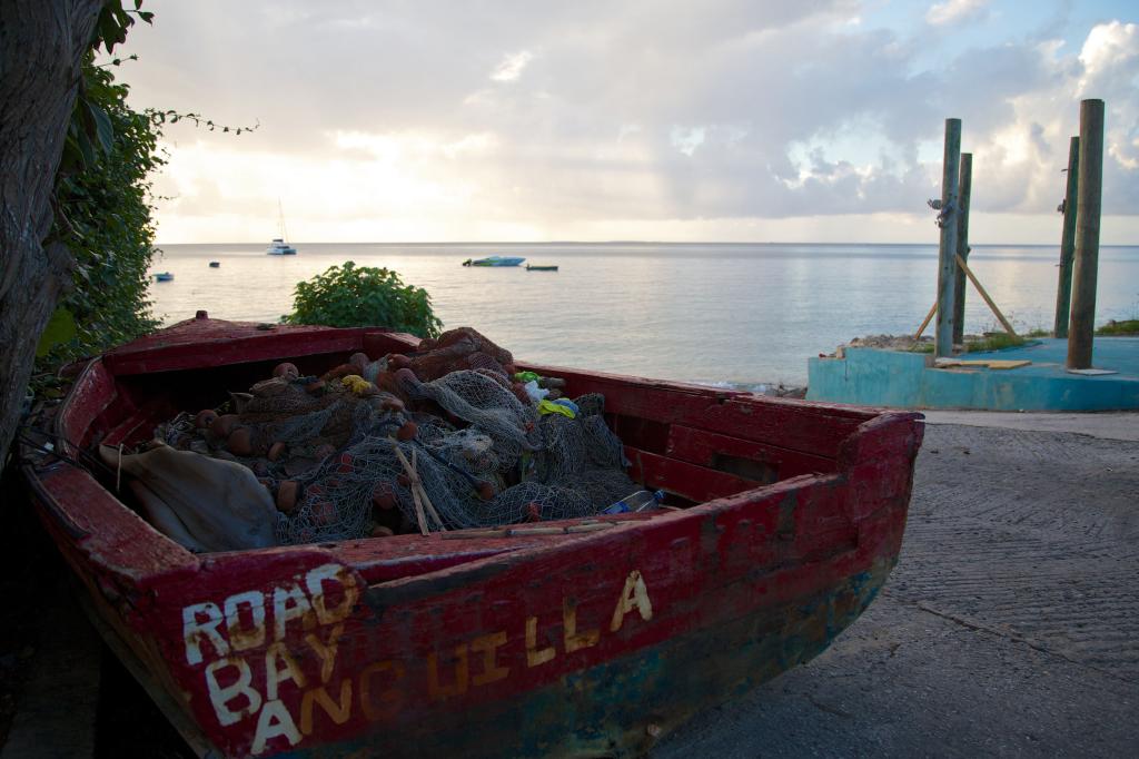 a small fishing boat sits on the seashore in Anguilla, a British overseas territory