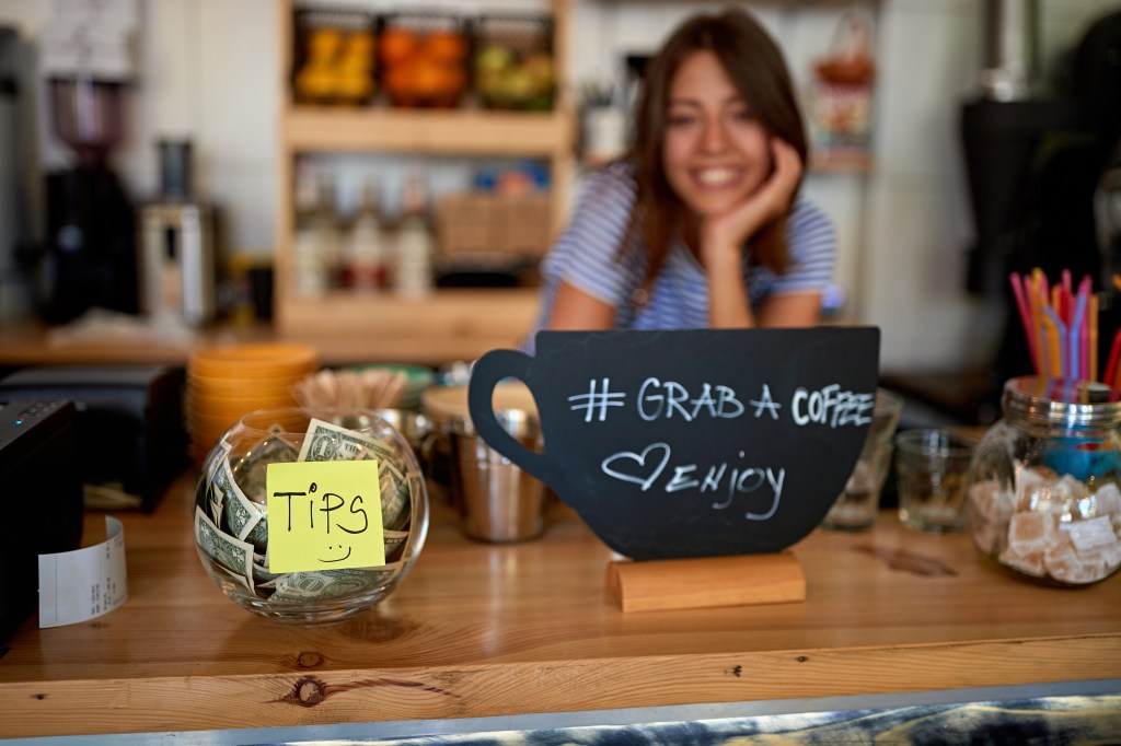 tips jar and grab sign for coffee at new open cafe.