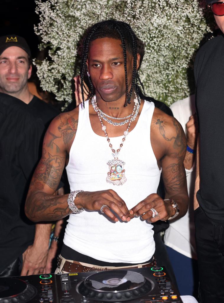 Travis Scott performing at Sinan's Art Basel Party in Miami, Florida, dressed in a white tank top and necklaces