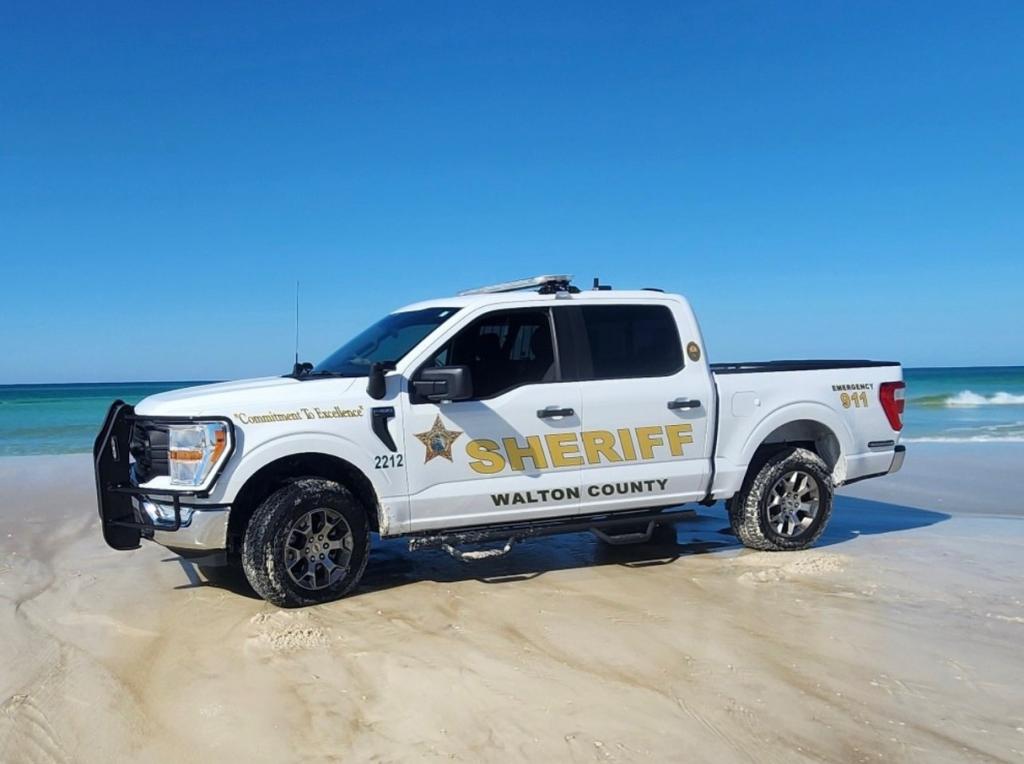 A sheriff truck on the beach. 