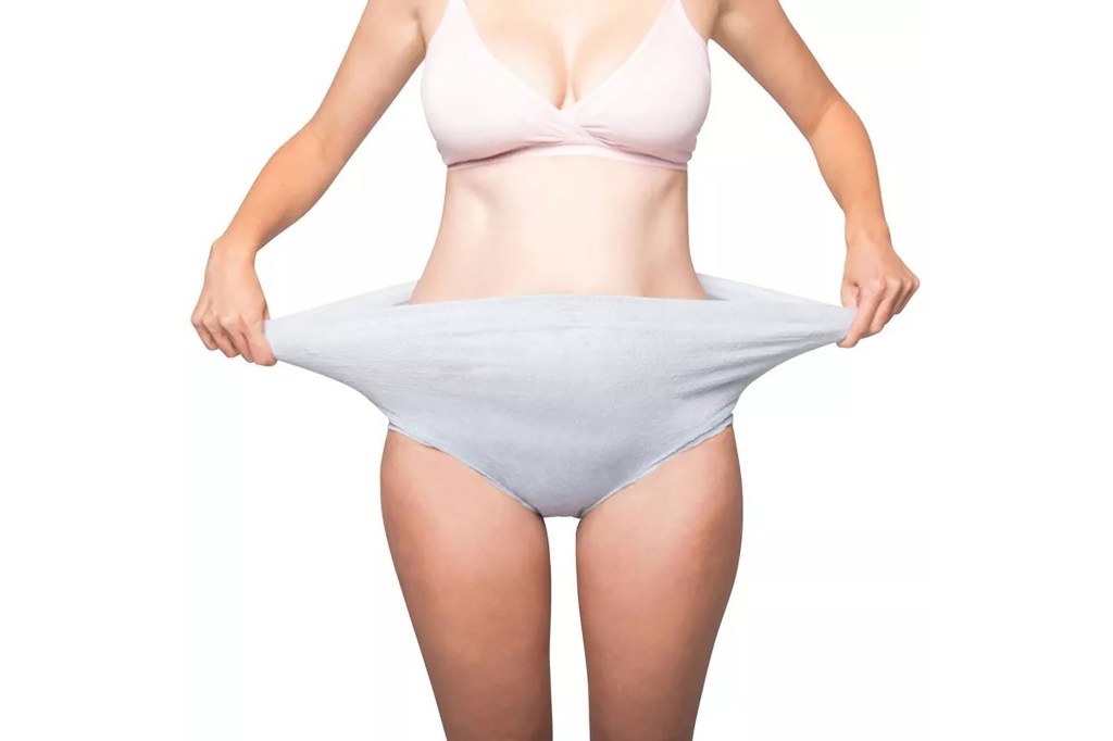 A woman in underwear holding out her empty pants
