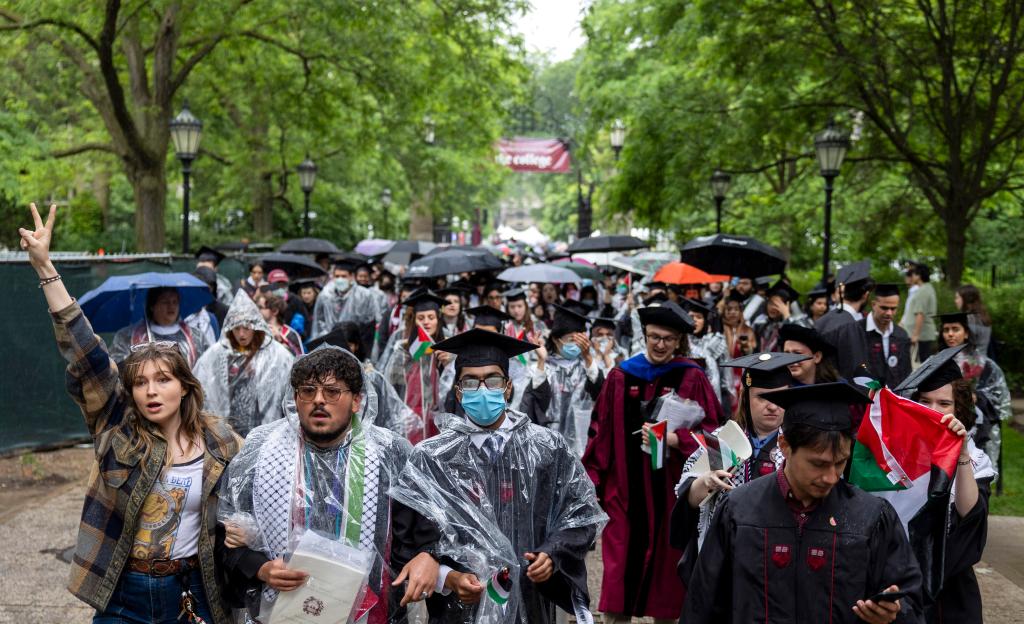 University of Chicago students, including Youssef Hasweh, walking out of the convocation ceremony in caps and gowns in support of Palestinians