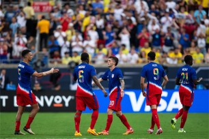 A group of men in sports uniforms on a field, featuring Christian Pulisic