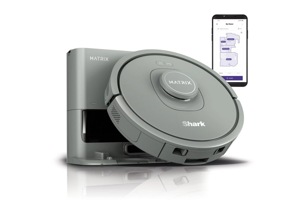 A grey robot vacuum cleaner next to a smartphone