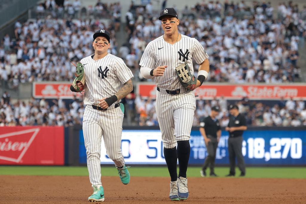 New York Yankees left fielder Alex Verdugo (24) and center fielder Aaron Judge (99) run off the field during the second inning against the Minnesota Twins at Yankee Stadium.