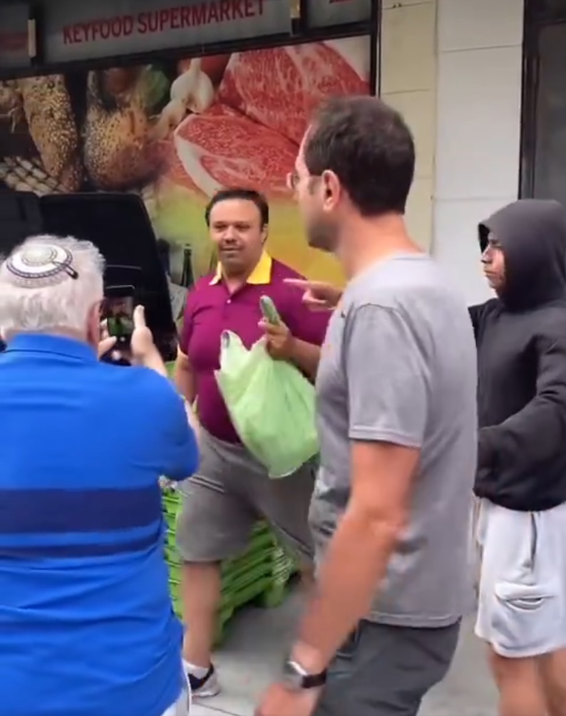 Bystanders surround the alleged bigot