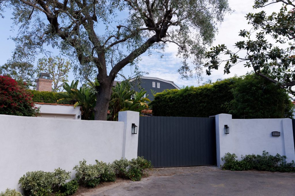 Front entrance of Marilyn Monroe's former Spanish Colonial-style house in Los Angeles, California, with a gate and tree, saved from demolition