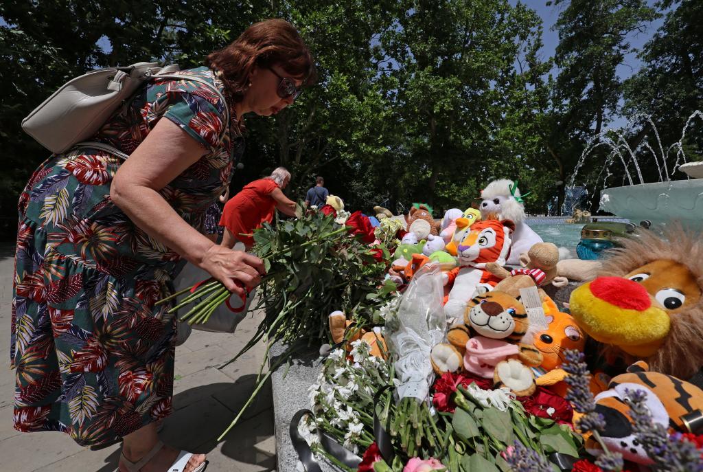 Woman laying flowers at a makeshift memorial for shelling victims in Sevastopol, Crimea during Russia-Ukraine conflict