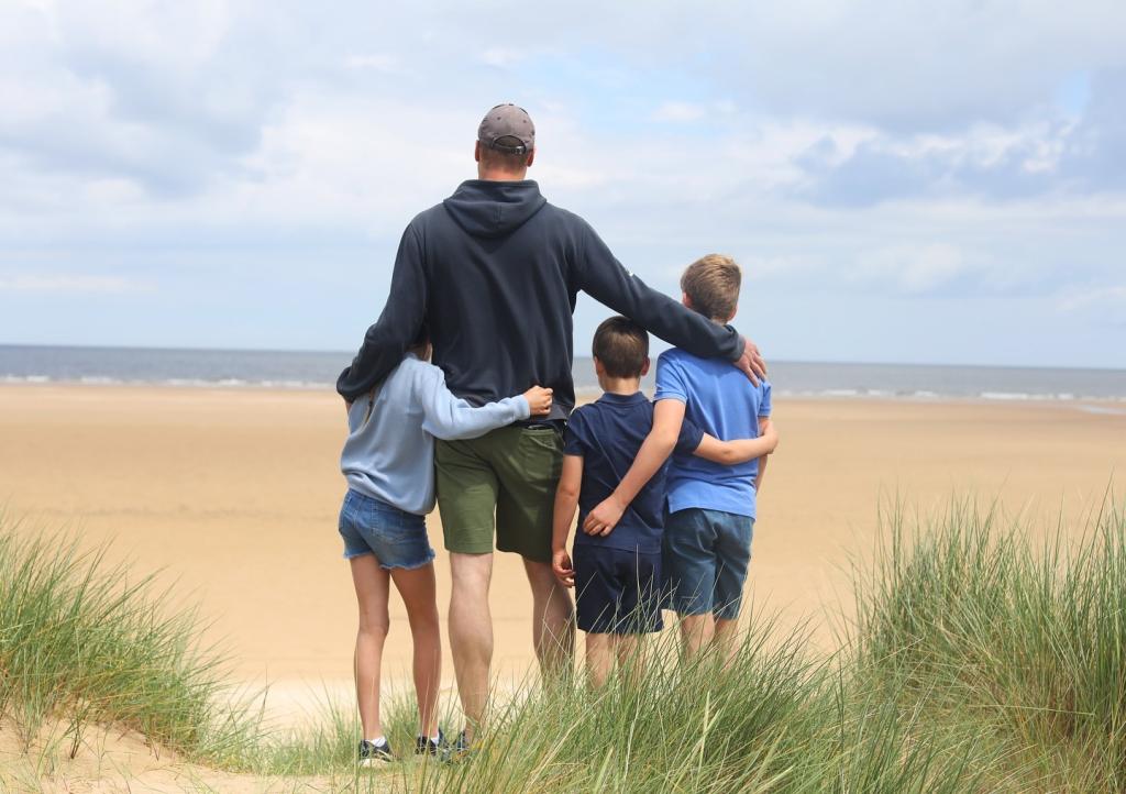 Prince William and his children standing on a beach, in a photo taken by Kate Middleton for Father's Day