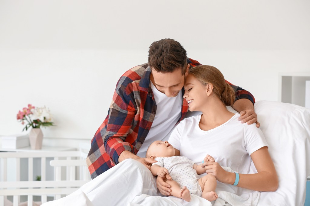 Young family with newborn baby in maternity hospital.