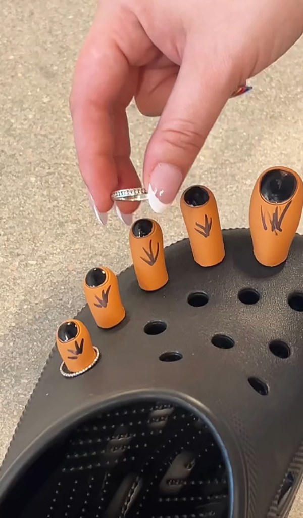  Crocs posted a video of black Crocs with toe-shaped jibbits as a person painted them as if they were toenails and adding accessories.