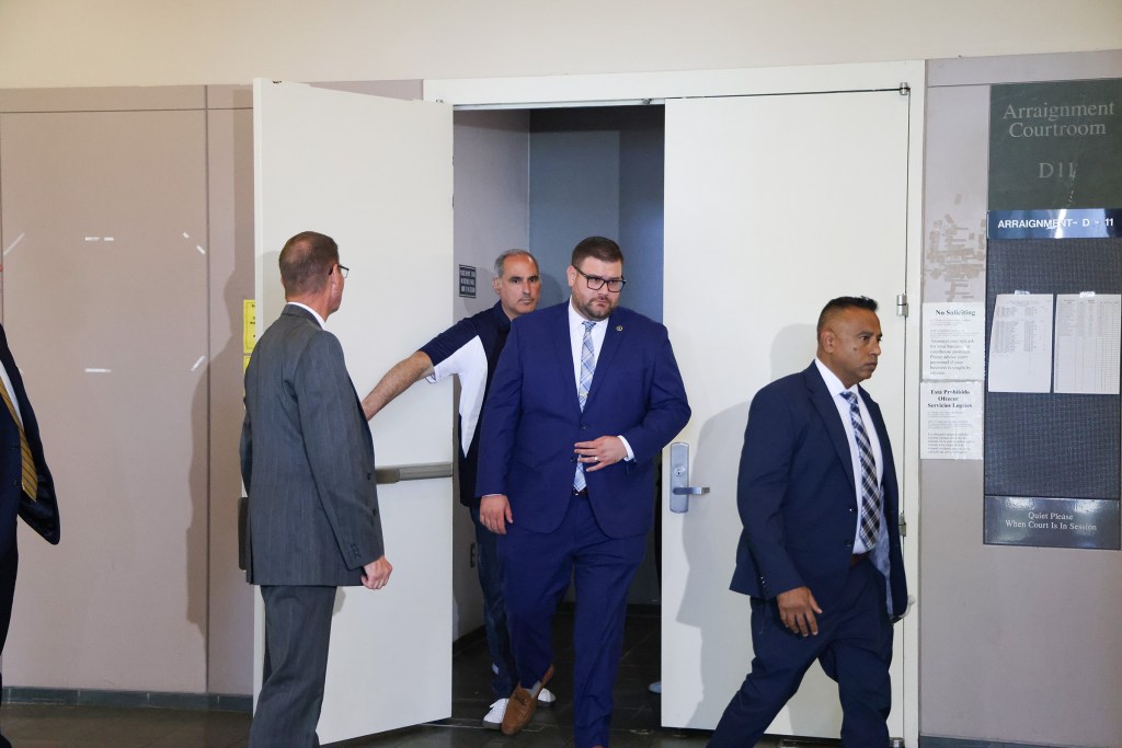 Carl Rennhack in a suit attending the arraignment of Steven Schwally in Suffolk County Criminal Court, Central Islip, NY