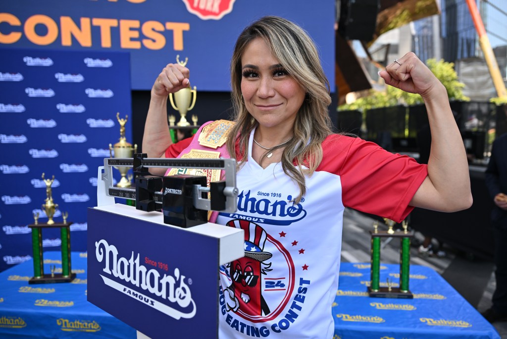 Miki Sudo, defending women's champion and world record holder at Nathan's Weigh-In ceremony in Hudson Yards Plaza, Manhattan, raising her arm