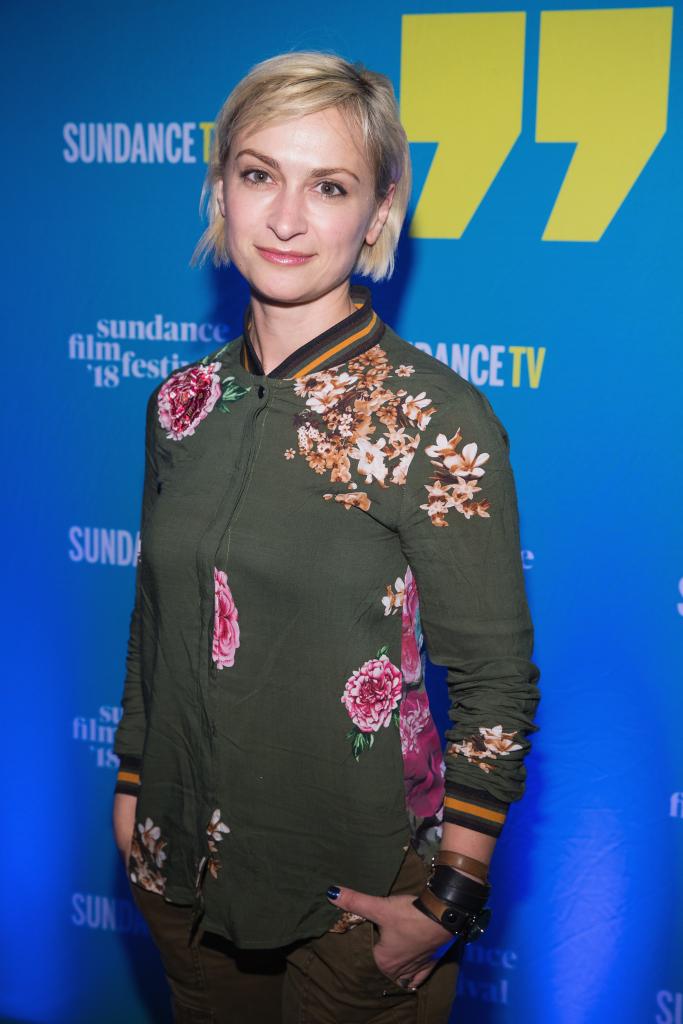 Filmmaker Halyna Hutchins attending the 2018 Sundance Film Festival Kickoff Party in front of a blue wall