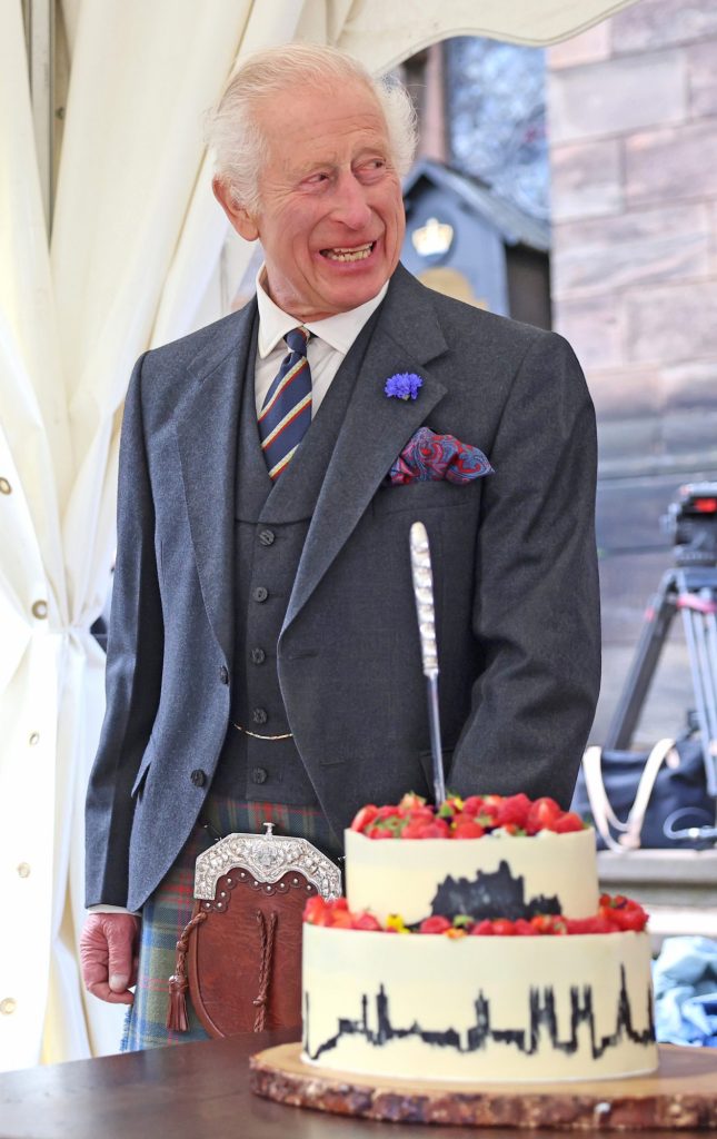 King Charles III laughing next to a cake baked by Peter Sawkins at the 900th Anniversary of Edinburgh, Scotland